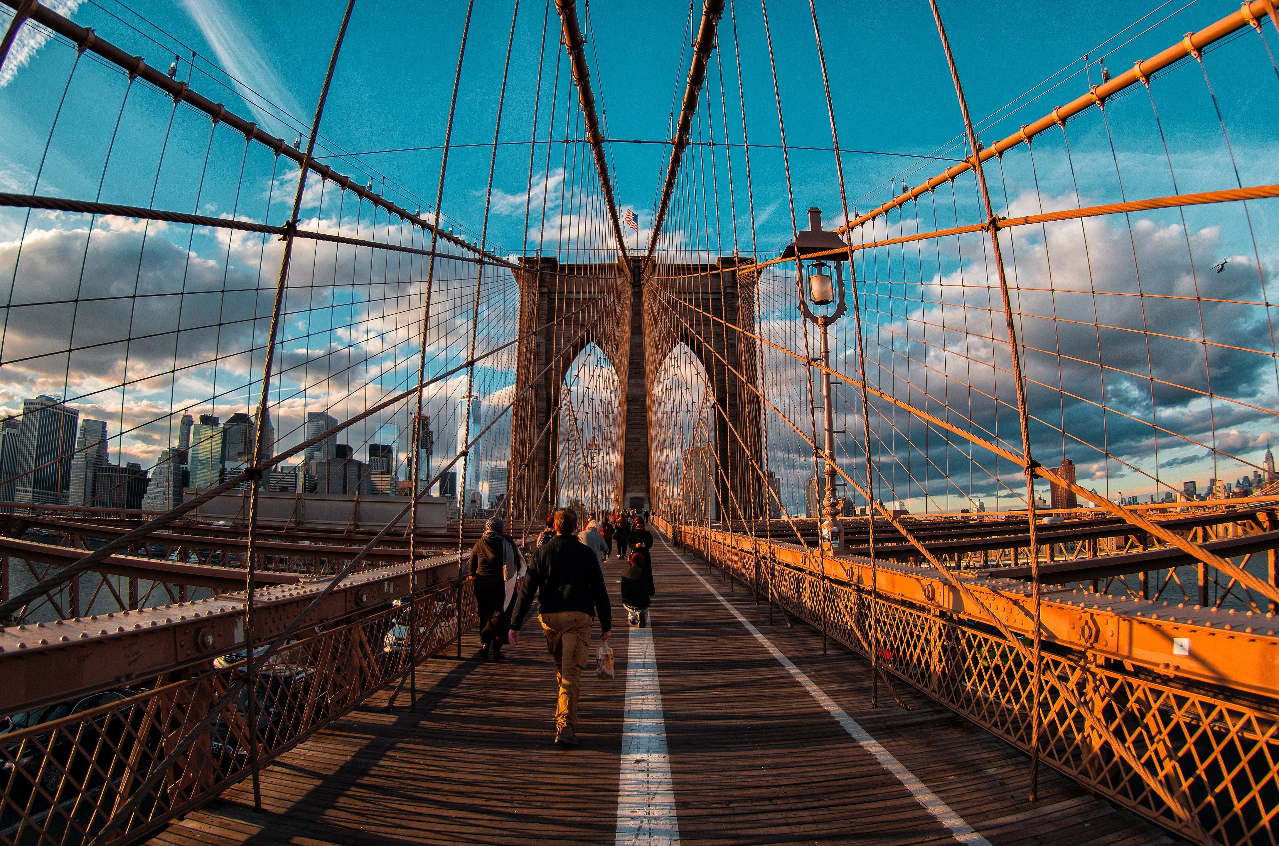 Pedestrians walk across Brooklyn Bridge in New York City