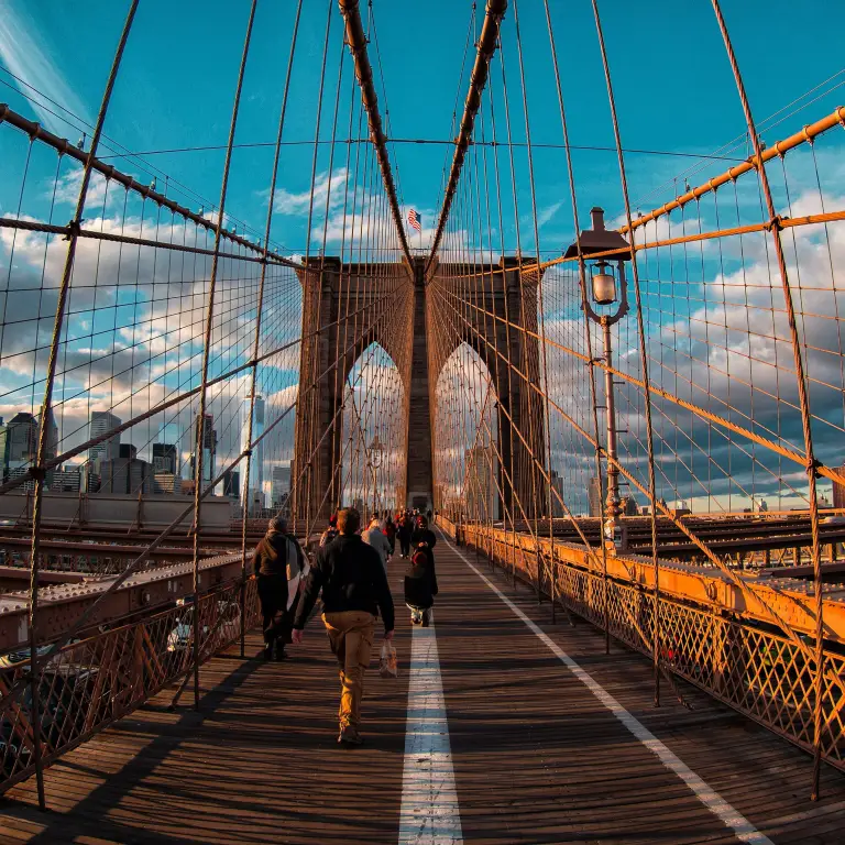 Pedestrians walk across Brooklyn Bridge in New York City