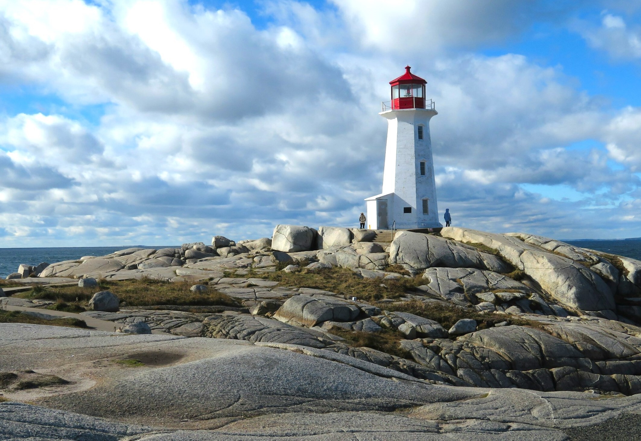 Ein weiß-roter Leuchtturm thront auf einem Felsvorsprung in Peggys Cove, Nova Scotia