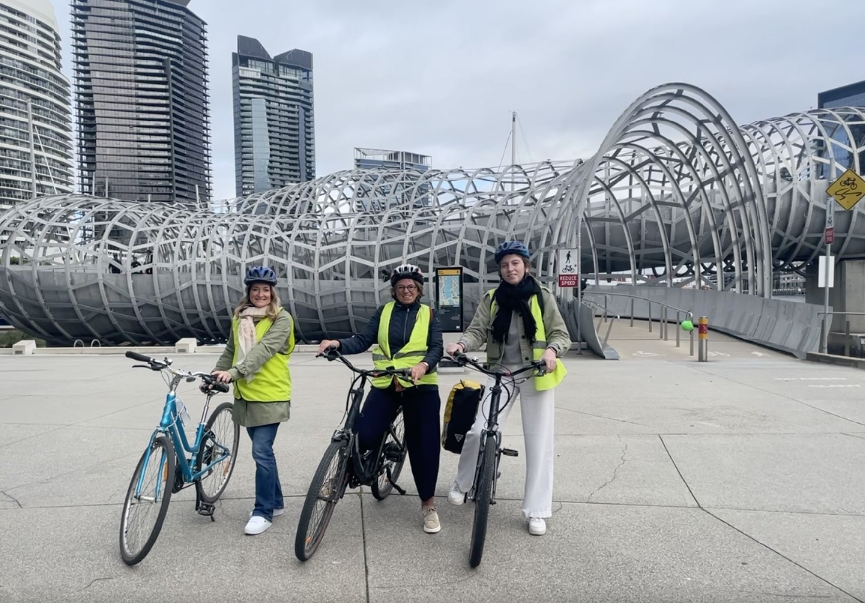 Drie vrouwen poseren met hun fiets in Melbourne