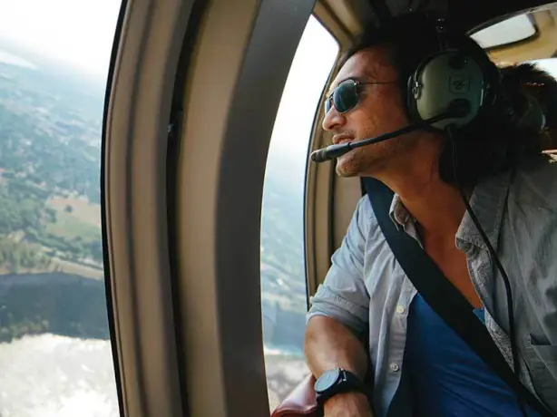 A man looking out the window of a helicopter above the Niagara Falls in Canada.