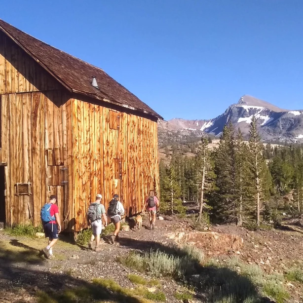 Eine Familie wandert an einer Holzhütte im Yosemite-Nationalpark, Kalifornien, USA, vorbei