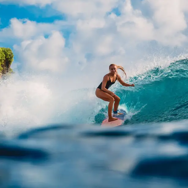 Een vrouw surft in Tahiti