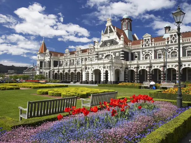Dunedin Railway Station, historisches großes Gebäude mit Blumengärten