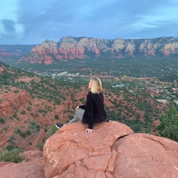 Vrouw op rots met uitzicht op de Grand Canyon