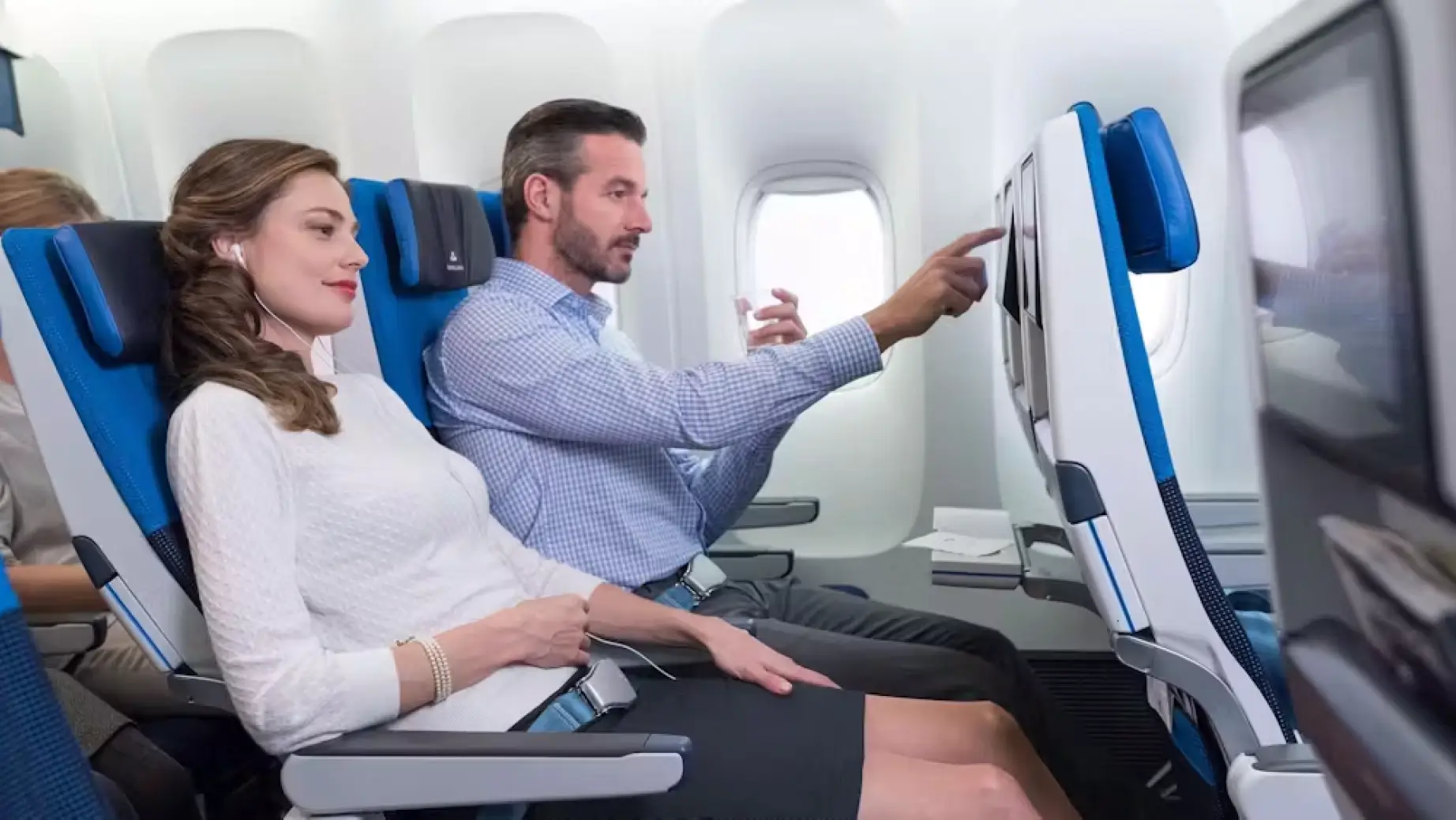 Zwei Personen genießen das Unterhaltungssystem an Bord in der Premium Economy