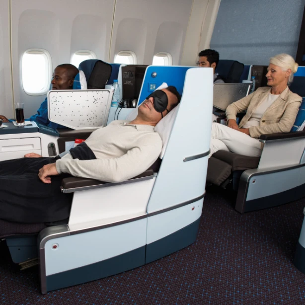 Passengers relaxing in lie-flat business class seats on an international flight.