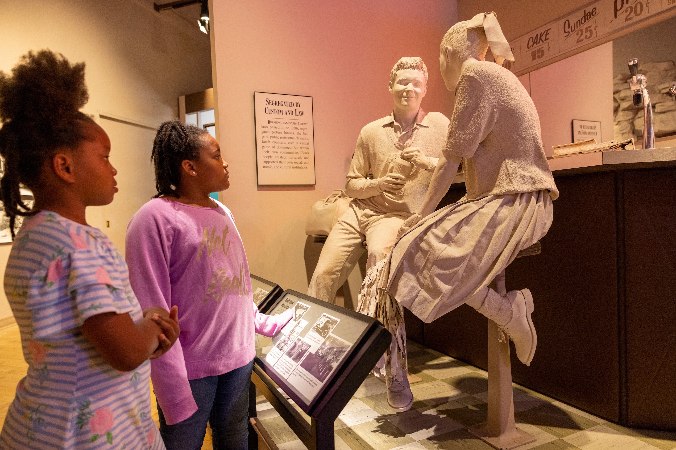 Zwei Mädchen betrachten Statue in Museum in Alabama