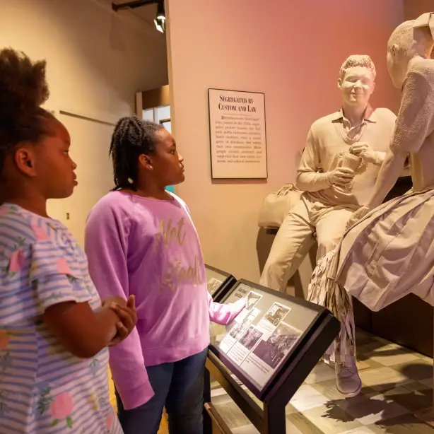 Zwei Mädchen betrachten Statue in Museum in Alabama