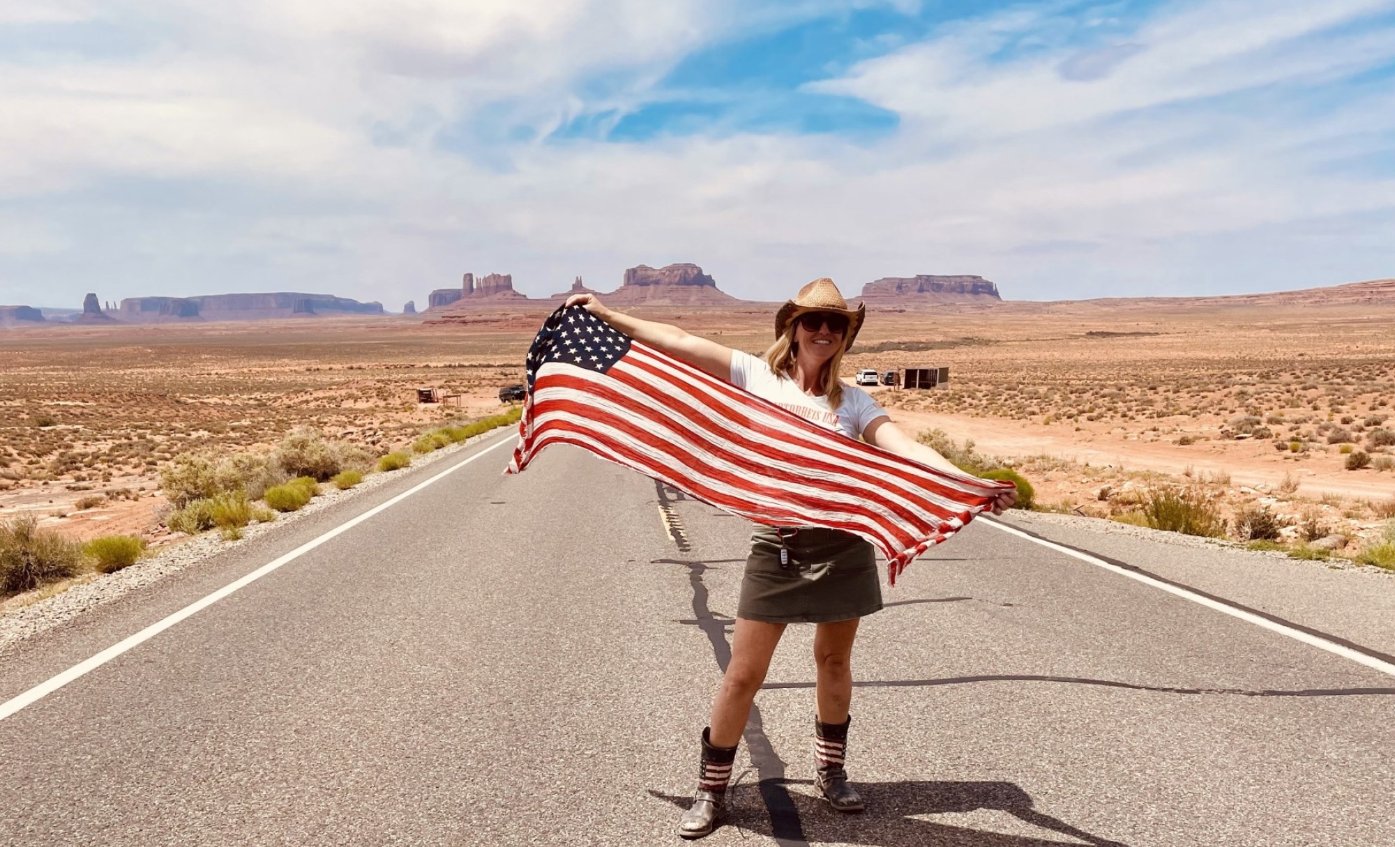 Travel expert Marjolein standing in the middle of the road with a flag in her hands.