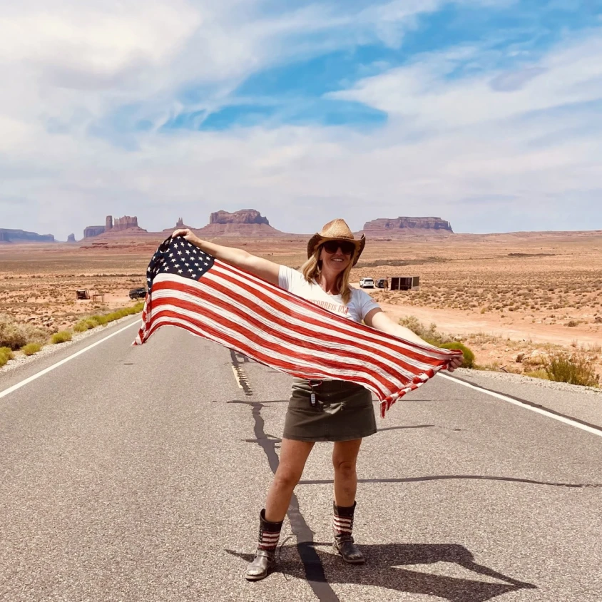 Travel expert Marjolein standing in the middle of the road with a flag in her hands.