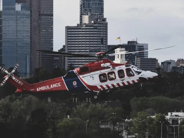 Hubschrauber mit Aufschrift "Ambulance" fliegt vor Hochhäusern
