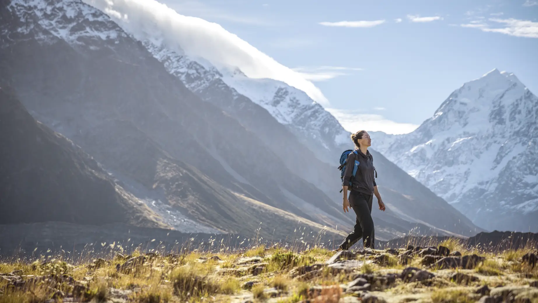 Frau wandert vor Bergpanorama in Neuseeland