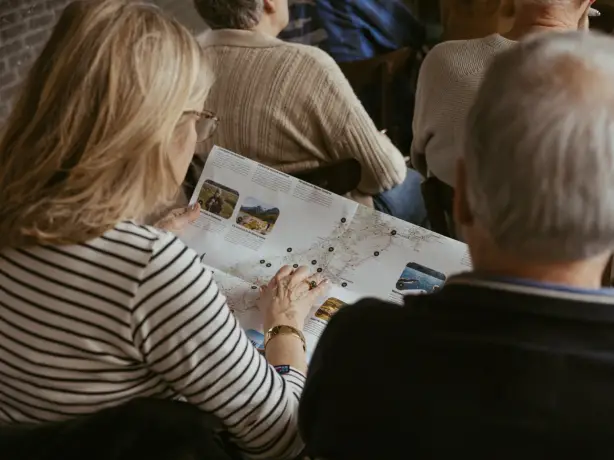 A man and a woman look closely at a map of New Zealand
