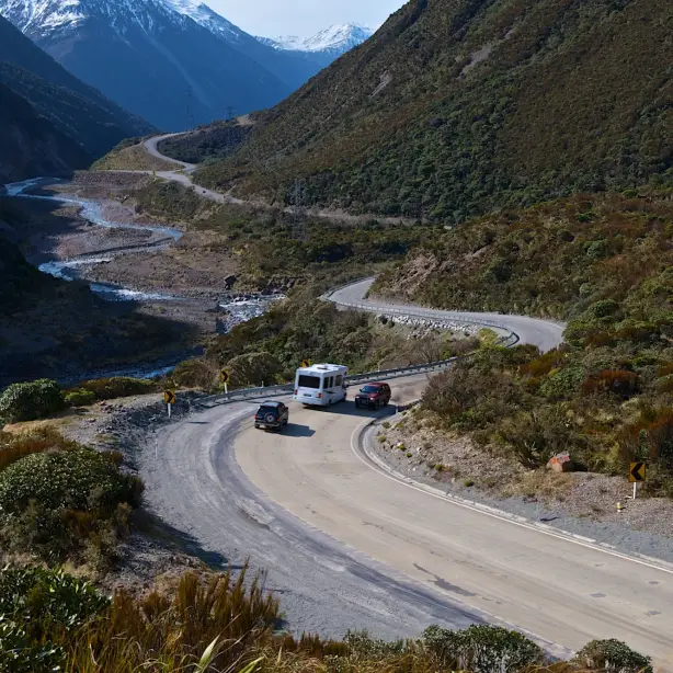 Zwei Autos und ein Wohnmobil fahren durch die neuseeländischen Berge