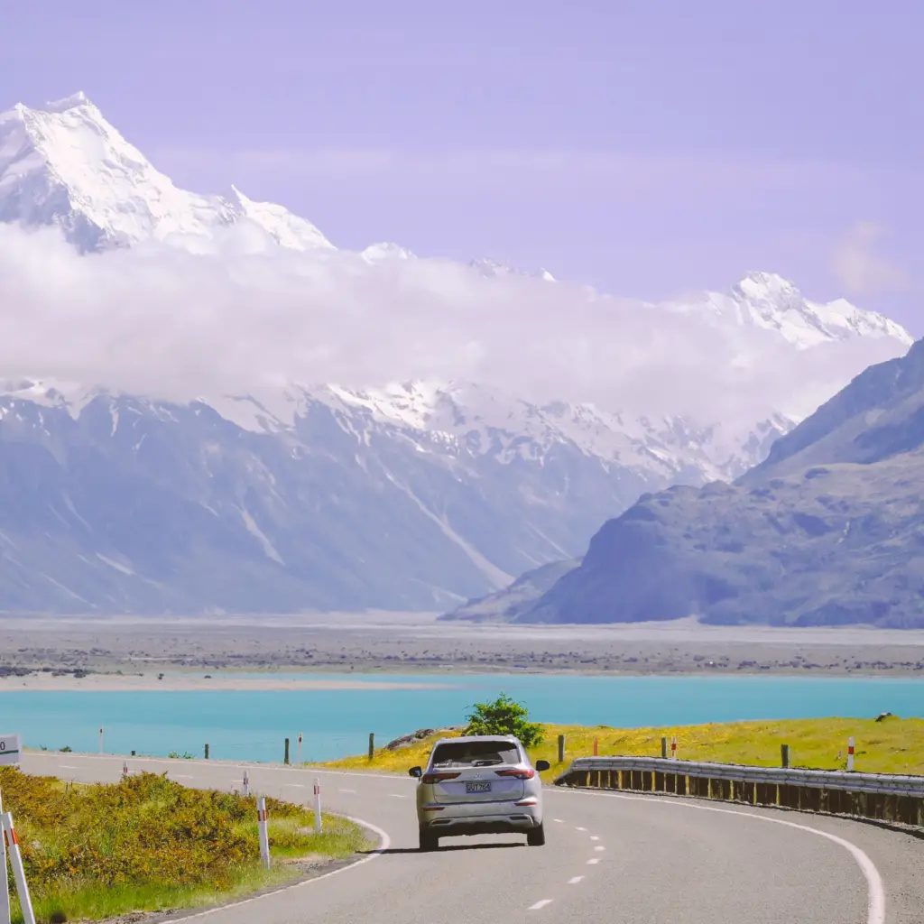 Een autorit over een schilderachtige weg langs het turquoise water van Lake Pukaki, richting de met sneeuw bedekte toppen van Aoraki Mount Cook, een autorondreis door Nieuw-Zeeland
