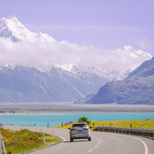 Een autorit over een schilderachtige weg langs het turquoise water van Lake Pukaki, richting de met sneeuw bedekte toppen van Aoraki Mount Cook, een autorondreis door Nieuw-Zeeland