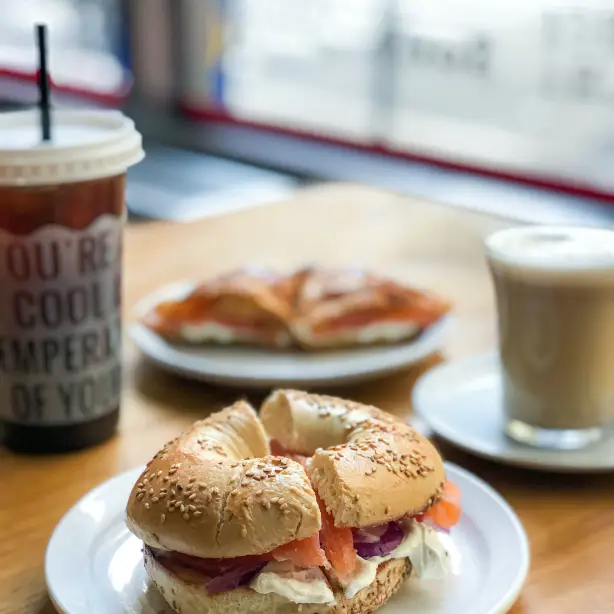 Een bagel met zalm en een ijskoffie op een tafel