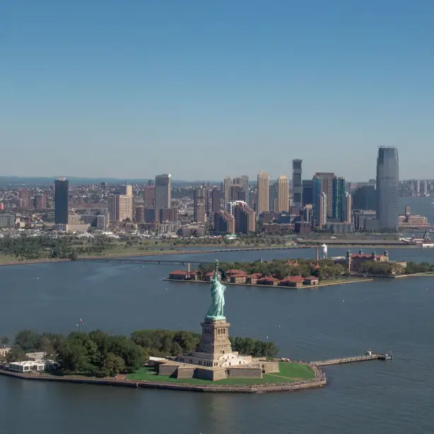 Uitzicht vanuit de lucht op de Statue of Liberty met wolkenkrabbers op de achtergrond