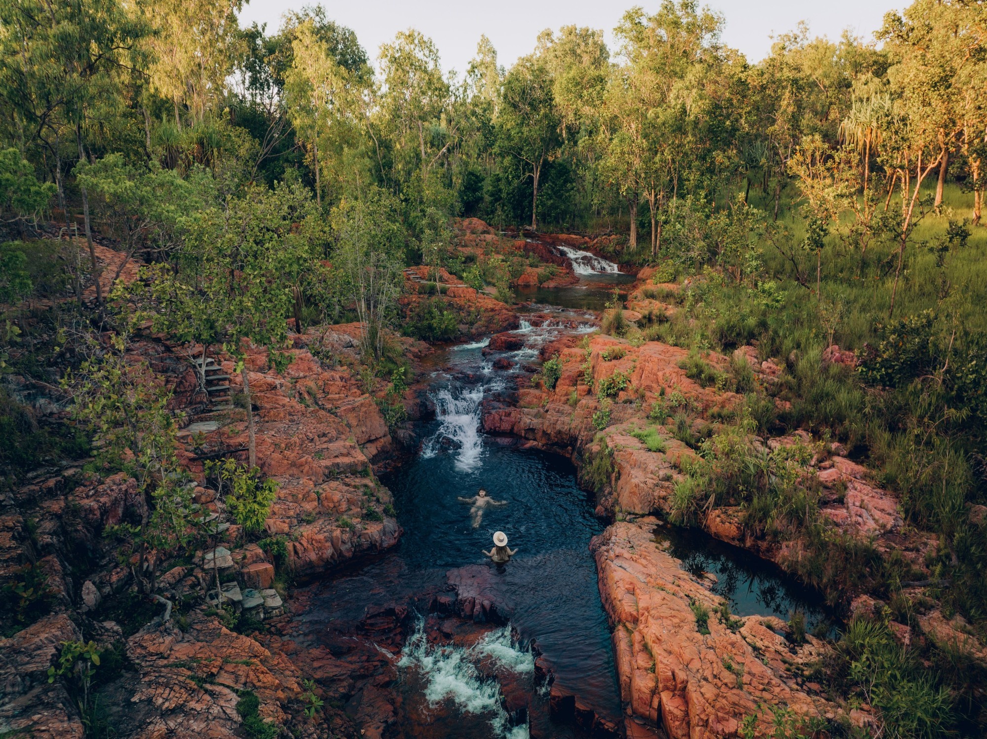 Menschen, die in einem kleinen Bach im Litchfield-Nationalpark bei Buley Rock schwimmen.