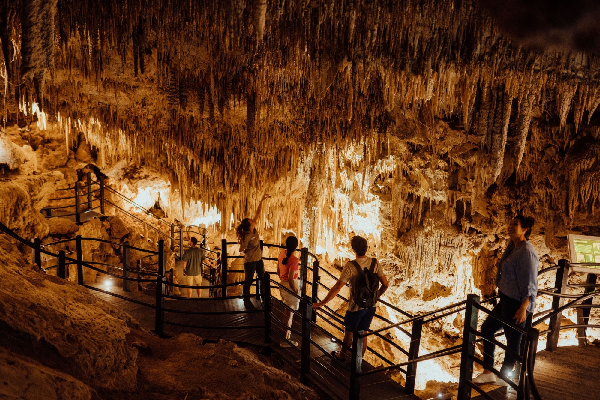 Personen bestaunen Stalaktiten in beleuchteter Höhle in Westaustralien