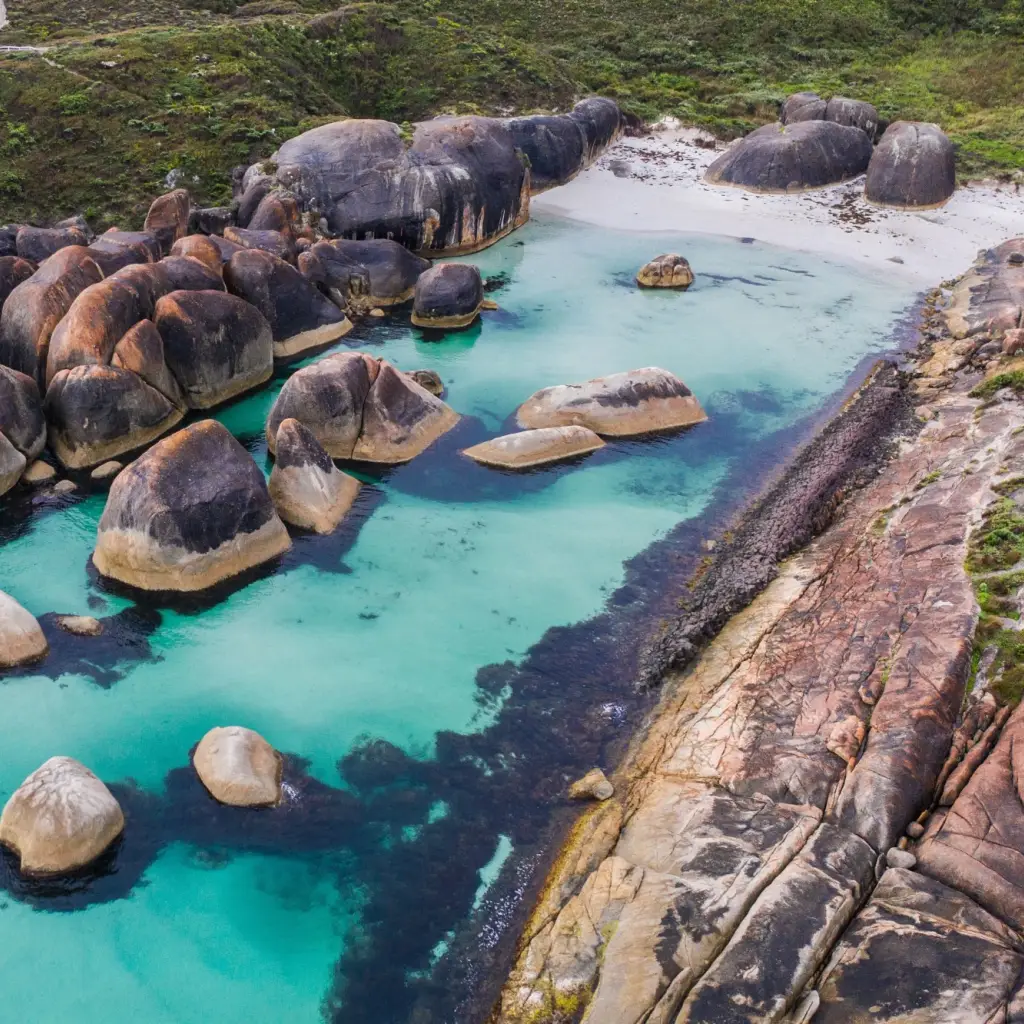 Große runde Felsen liegen in türkiser Bucht von Westaustralien