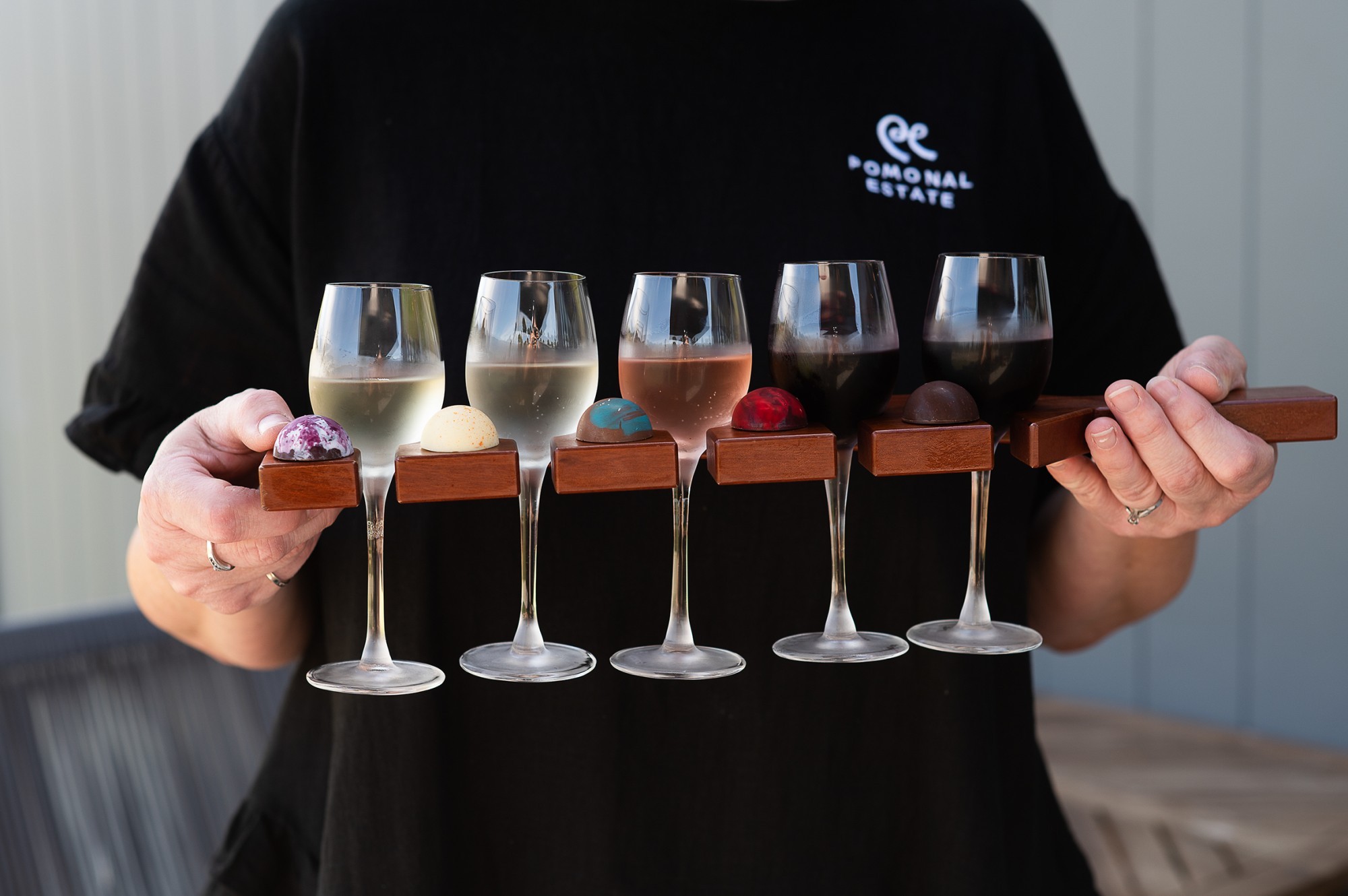 Frau hält fünf Weinproben in der Hand