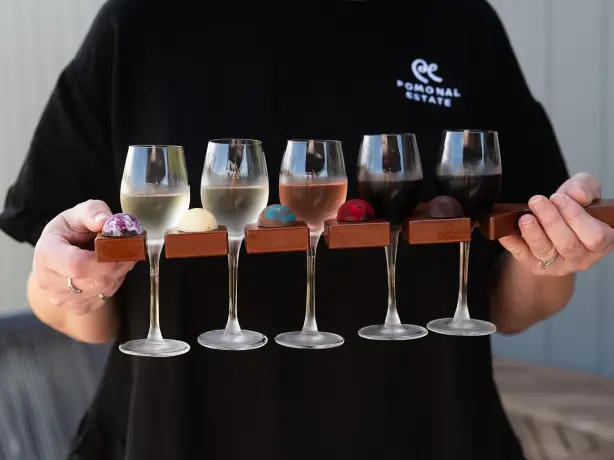 Frau hält fünf Weinproben in der Hand
