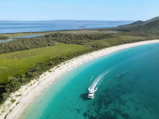 A boat moving across the coast of Wineglass bay in Australia
