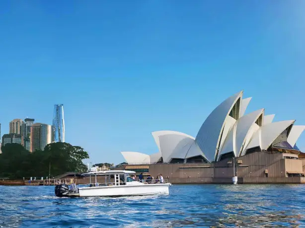 A boat sailing in front of Sydney Opera House in Australia