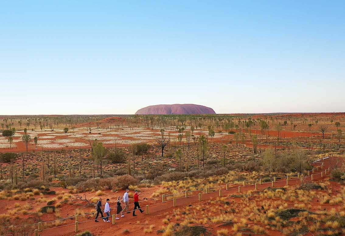 People walking along a path through the Uluru National Park in Australia