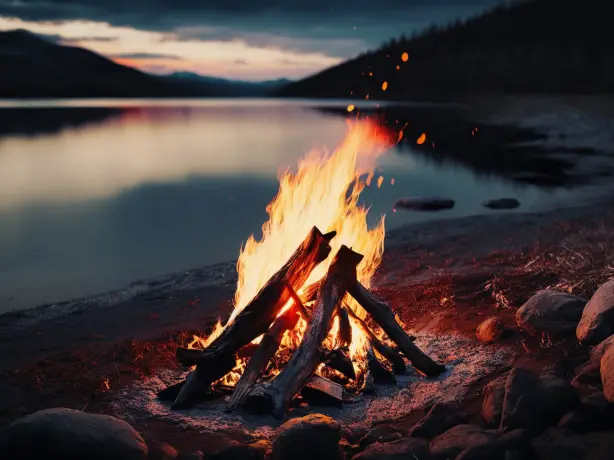 Lagerfeuer am ruhigen Seeufer bei Sonnenuntergang in Kanada