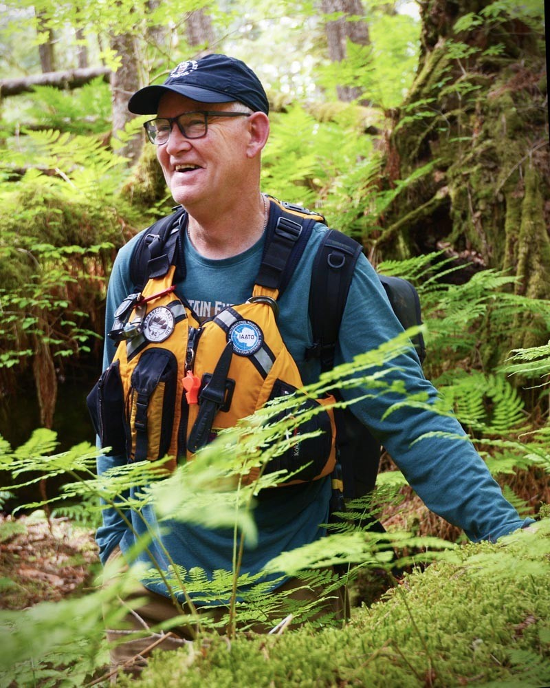 Ein lokaler Guide mit Sicherheitsweste in Regenwald in British Columbia