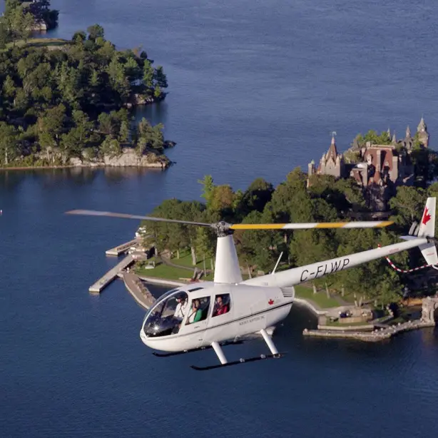 Hubschrauber fliegt über kleine Insel mit Schloss im Osten Kanadas