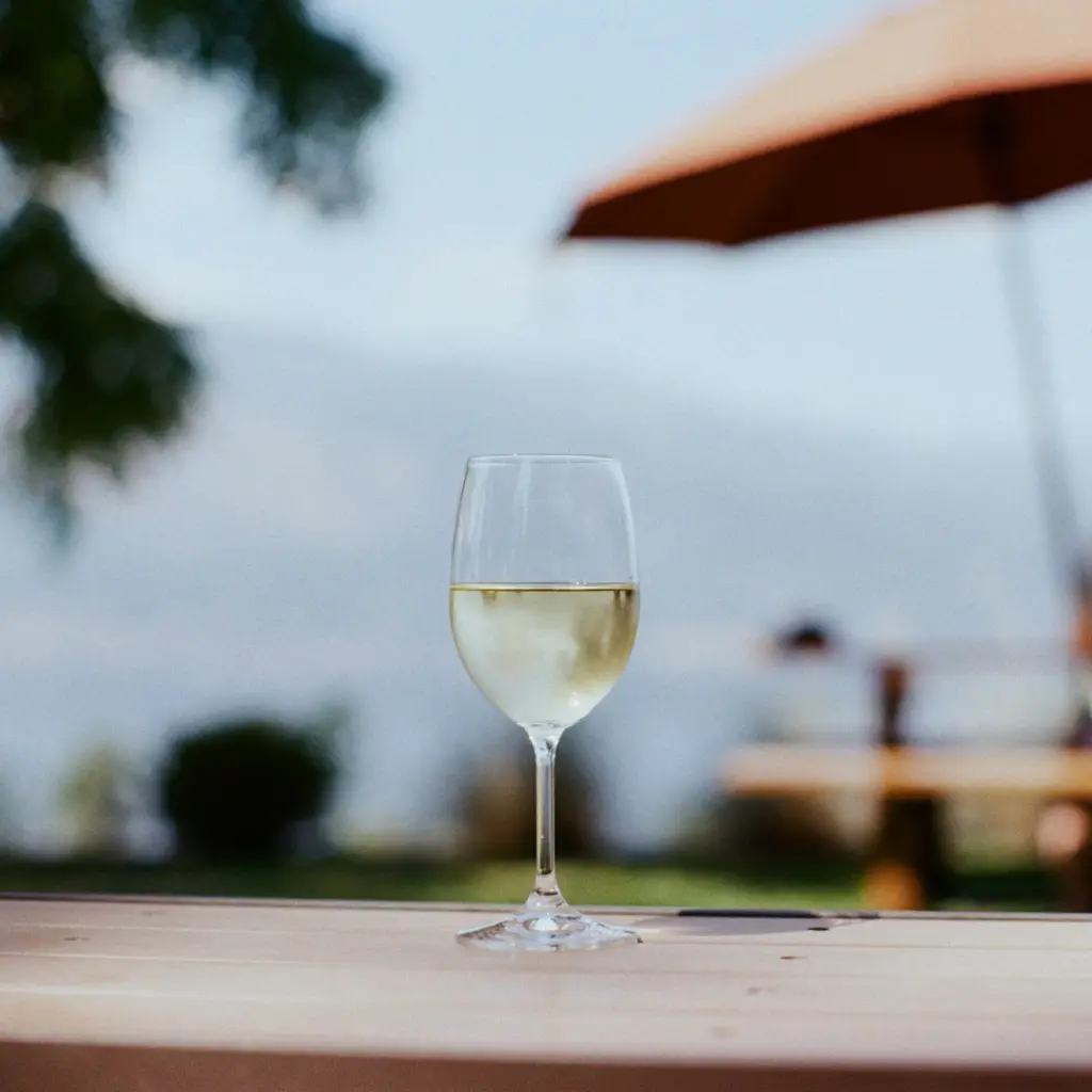 Ein Glas Weißwein auf einem Tisch im Freien