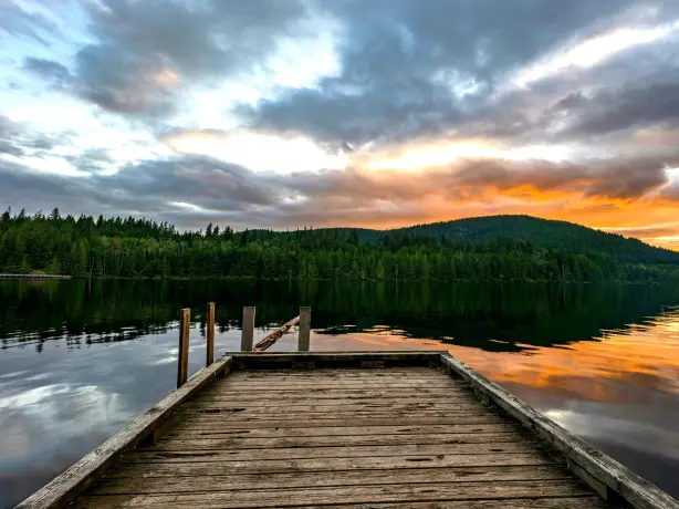 Ein kleiner Holzsteg ragt in den Powell River an der kanadischen Sunshine Coast hinein, während in der Nähe die Sonne untergeht