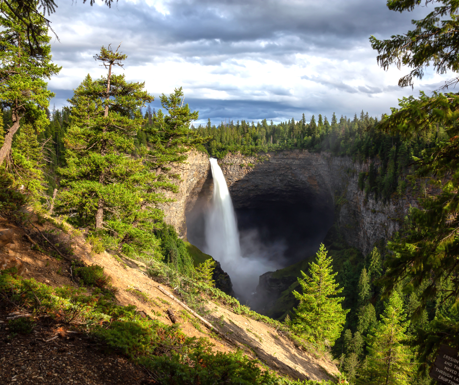 Großer Wasserfall umgeben von Klippen und Bäumen in Wells Gray
