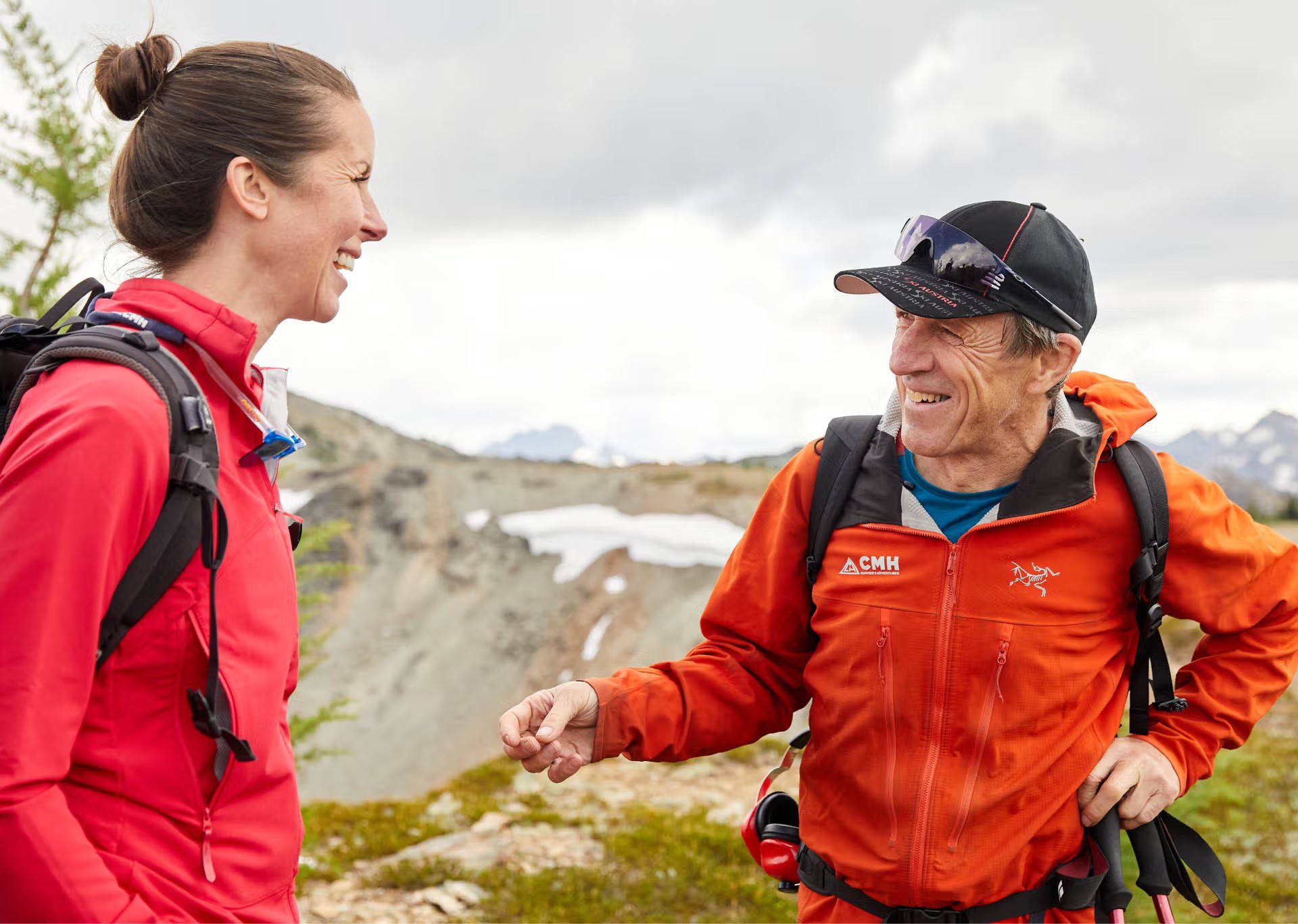 A local guide smiling and talking to a hiker in the mountains of British Columbia
