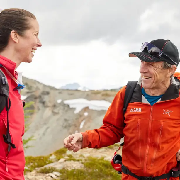 Lokaler Guide lächelt Frau auf Wandertour an in den Bergen von British Columbia