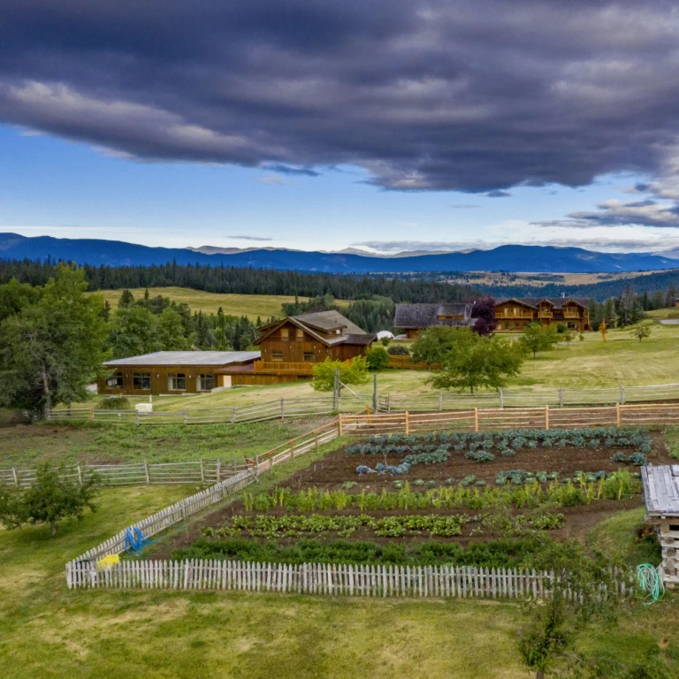 Ranch in Kanada mit Gemüsegarten und bergen im Hintergrund
