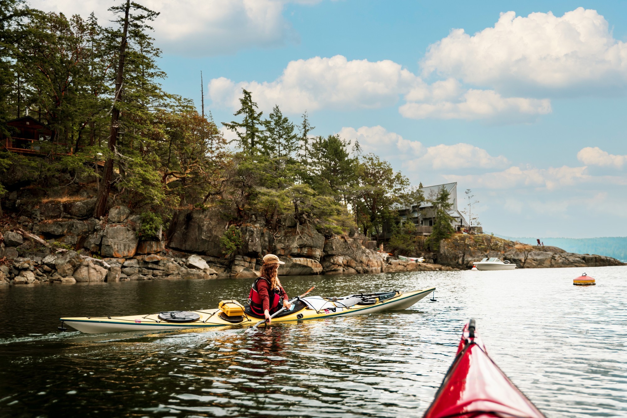A woman kayaking along the shoreline of sunshine coast