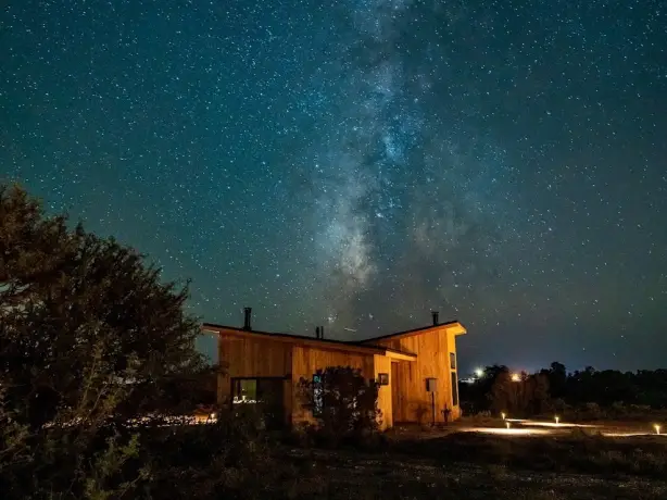 Wooden house accommodation at night, surrounded by stars in the Grand Cayon