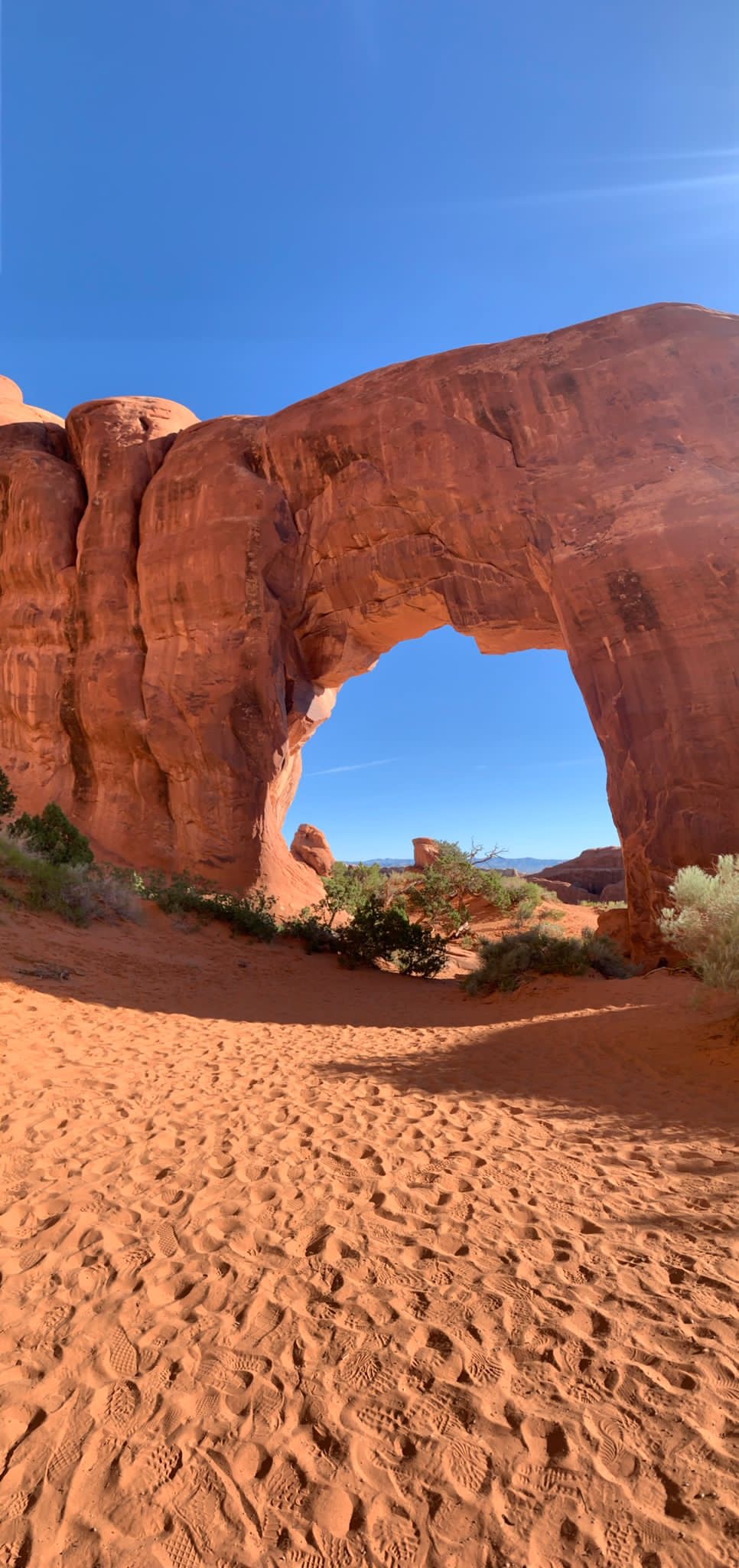 Roter Felsbogen auf rotem Sand in den USA
