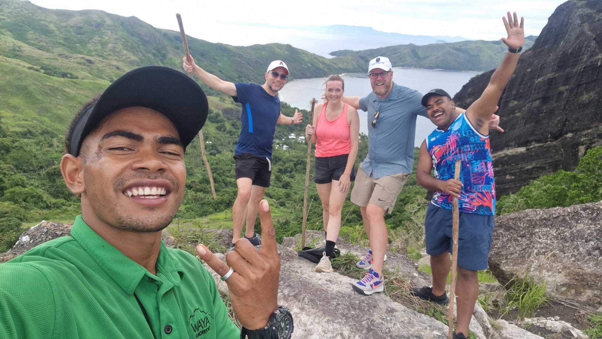 Groep wandelaars nemen een selfie met oceanen en heuvels op de achtergrond in Fiji