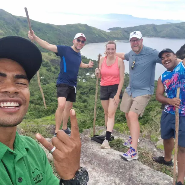 Groep wandelaars nemen een selfie met oceanen en heuvels op de achtergrond in Fiji