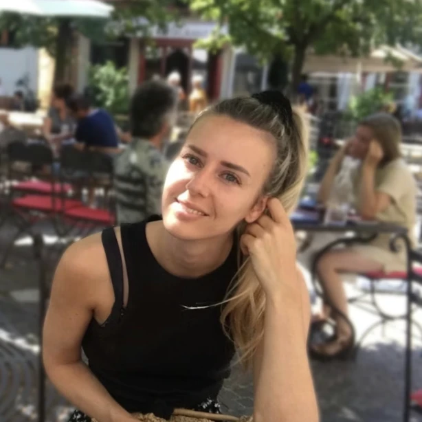 Gerbrich glimlacht naar de camera terwijl hij buiten in een restaurant zit te eten