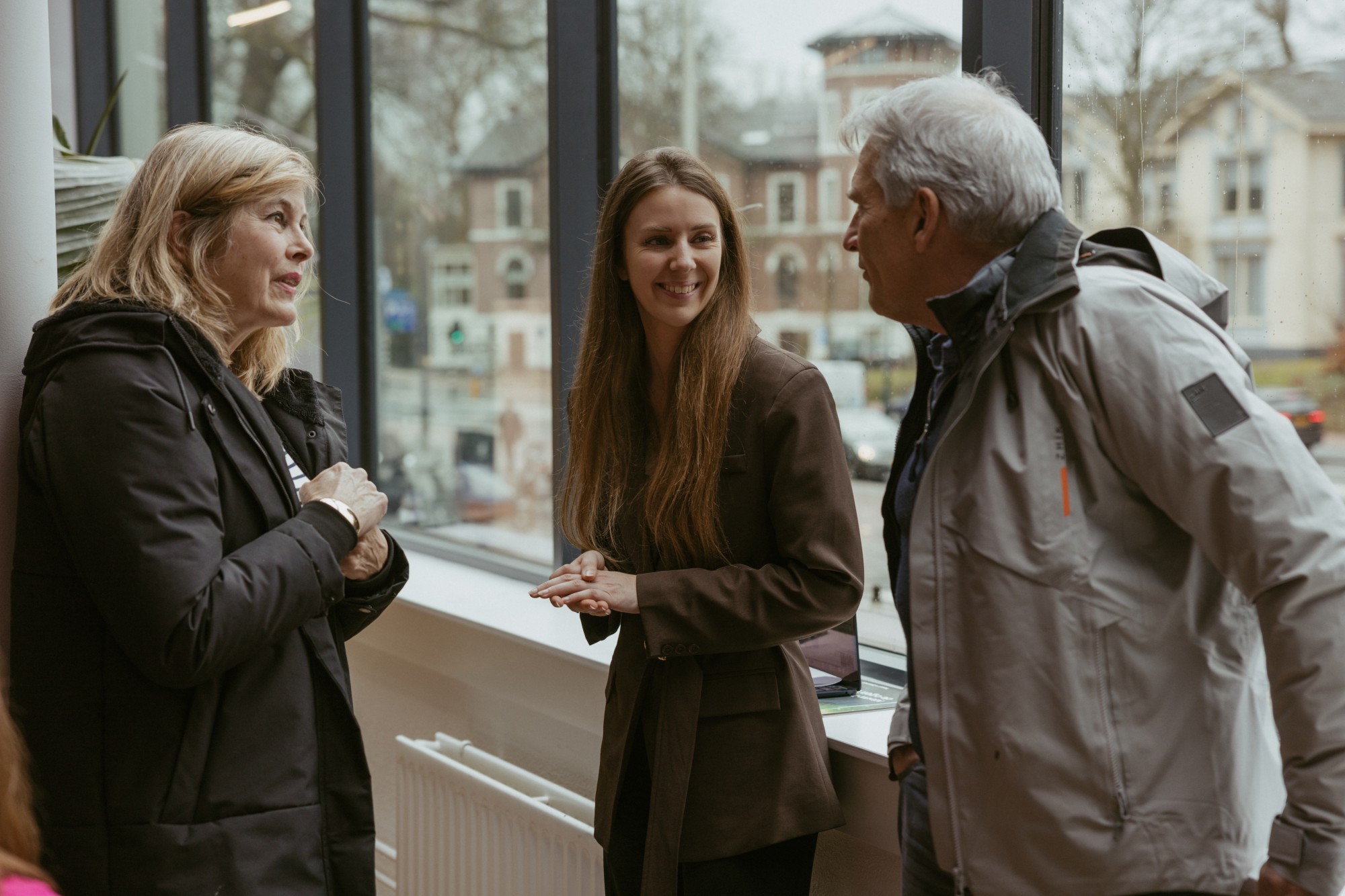 Vrouw en man die in gesprek zijn met een jonge vrouw.