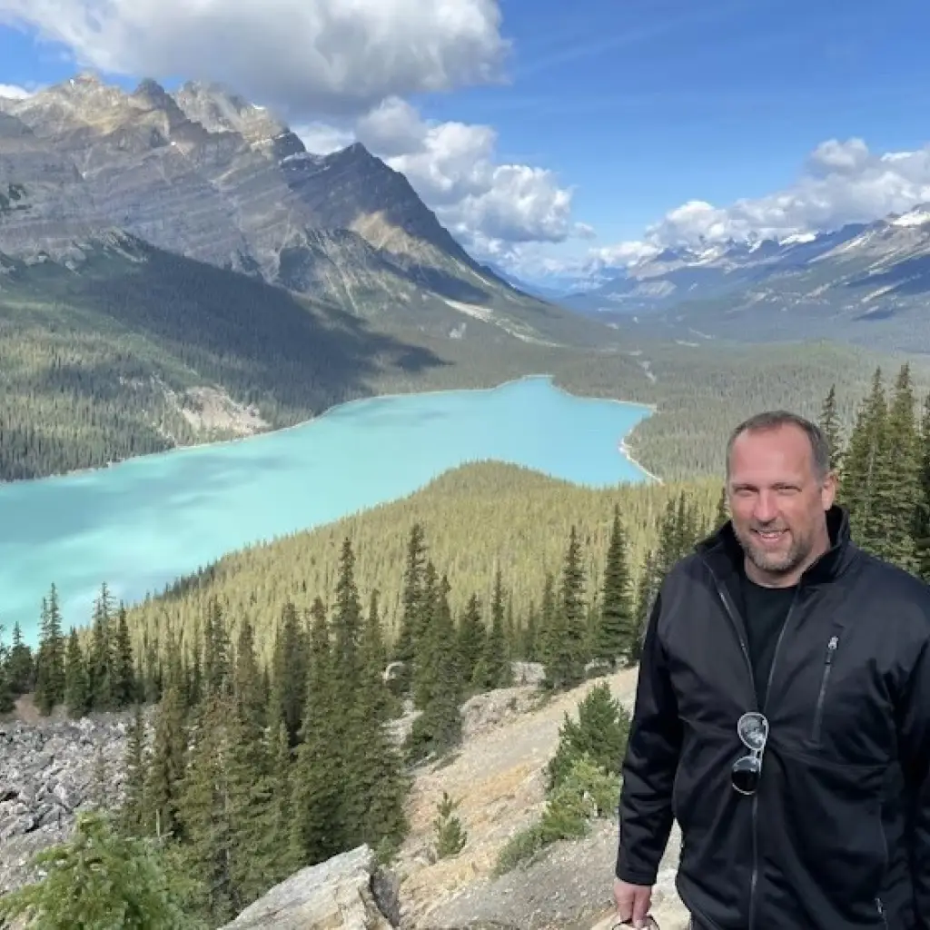 Mann steht vor Bergen und See in Kanada