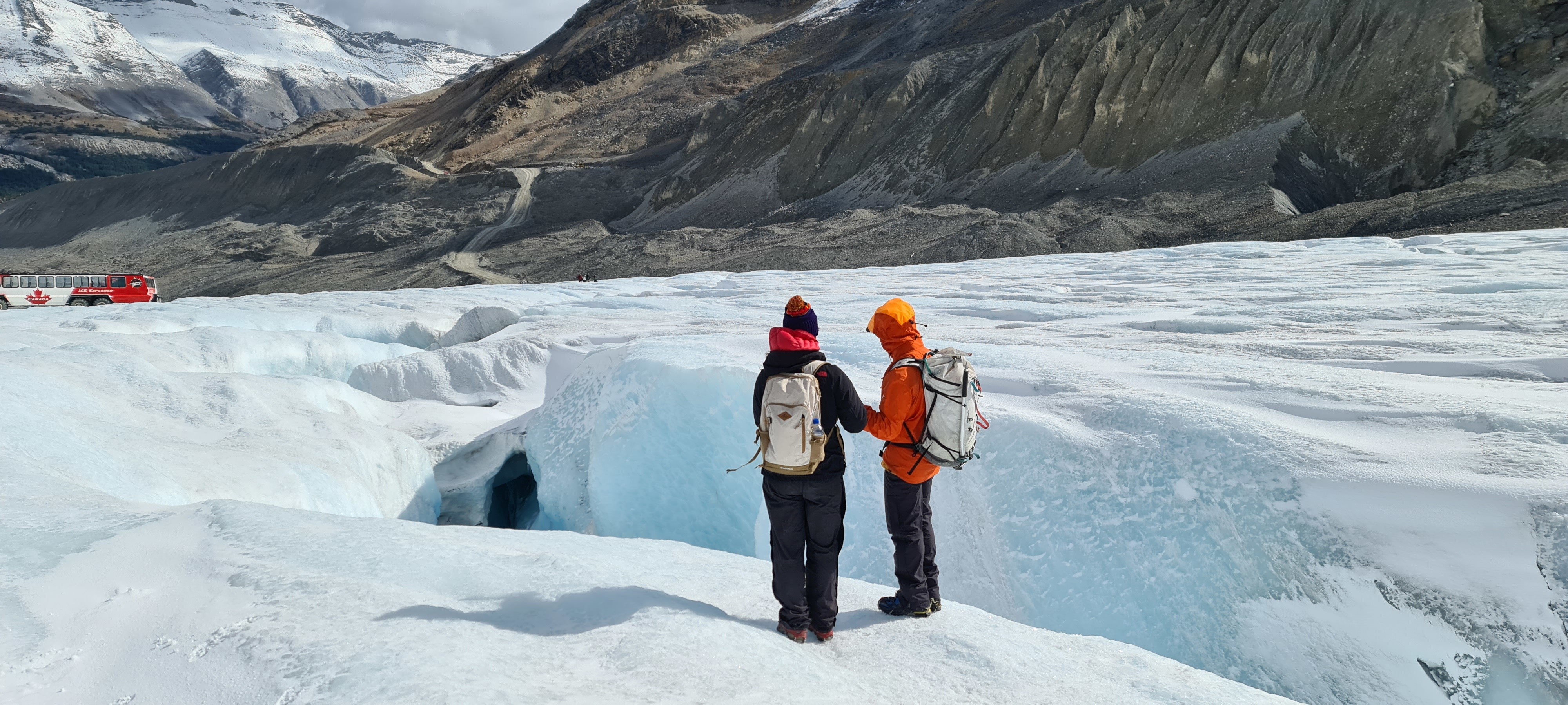 Zwei Personen mit Rucksäcken stehen auf Gletscher in Kanada