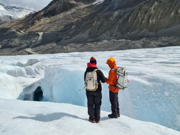 Zwei Personen mit Rucksäcken stehen auf Gletscher in Kanada